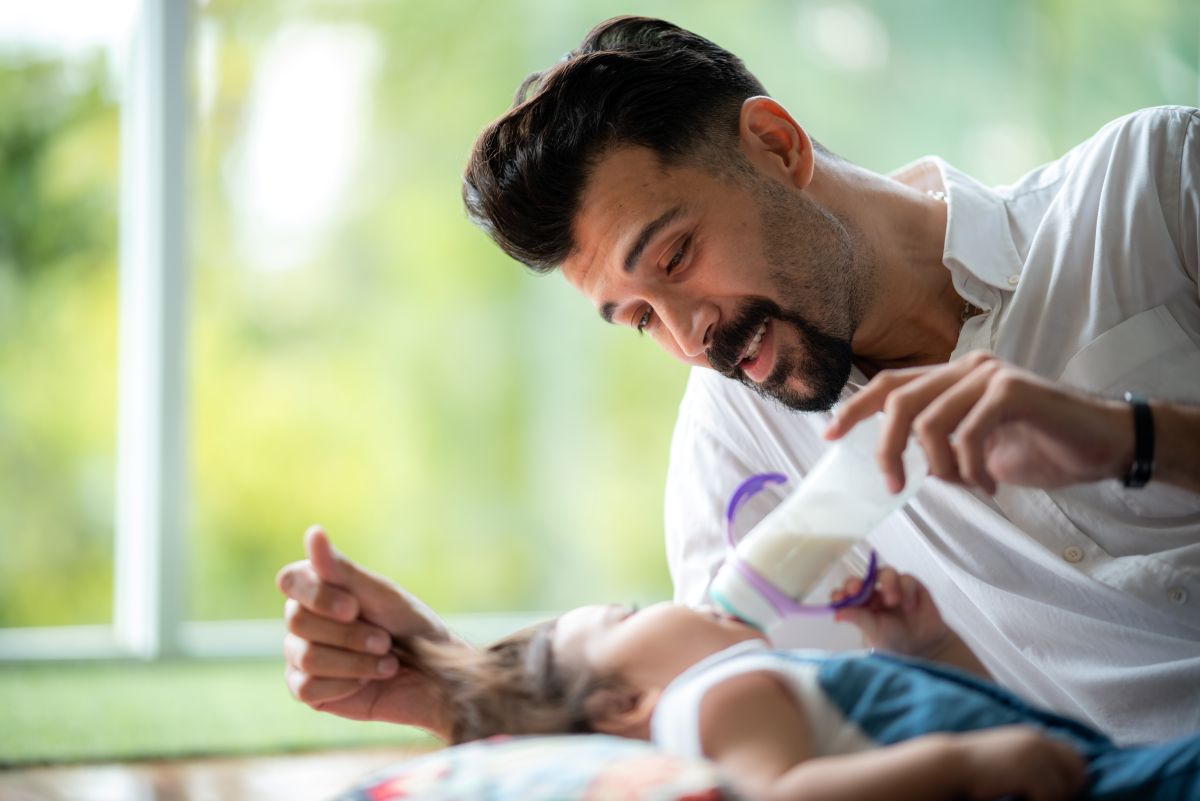 Un homme donne le biberon à son fils