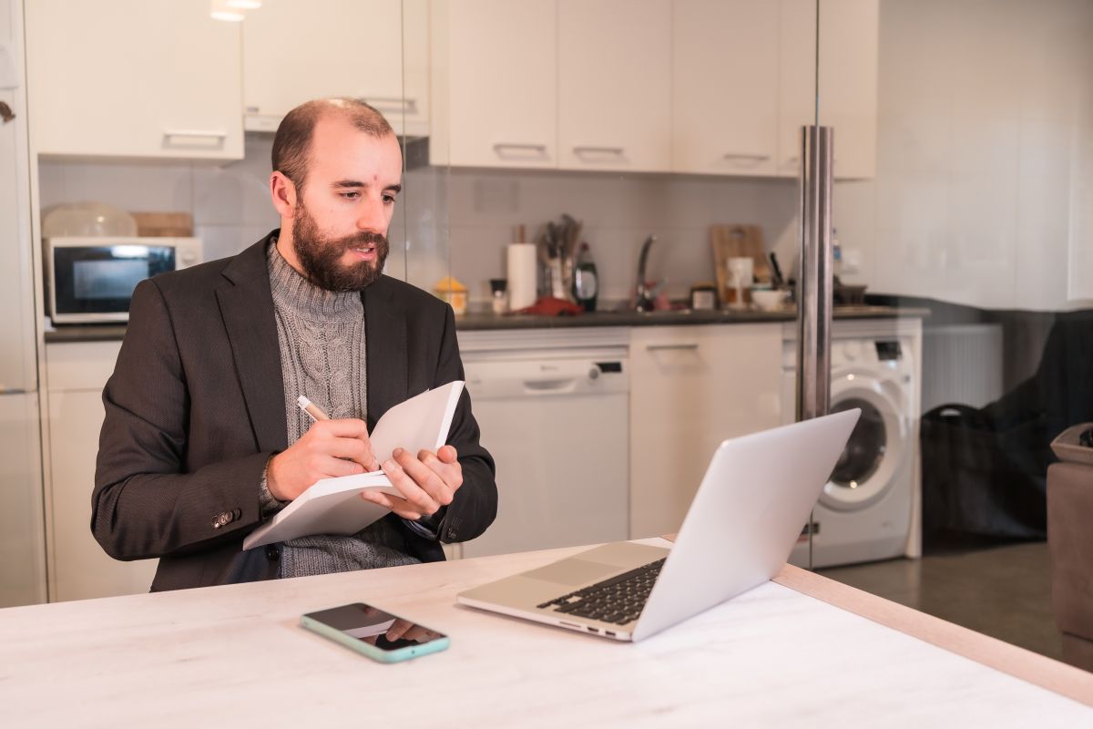 Un homme note des informations inscrites sur son PC