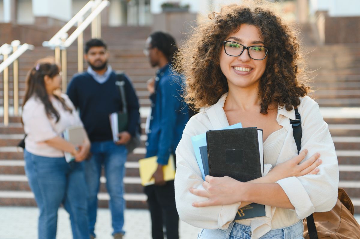 Une jeune diplômée devant son université