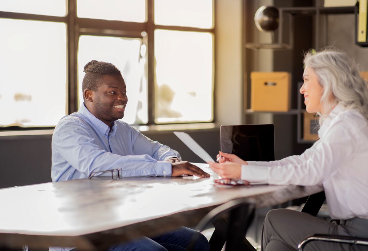 Une gérante discute avec un homme au sujet de l'emploi au bureau